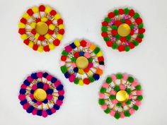 four colorful flower shaped buttons on a white surface