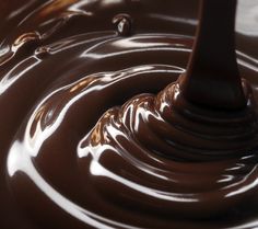 melted chocolate is being stirred by a spoon