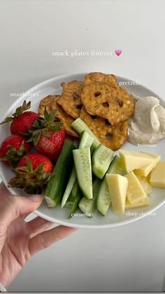 a white plate topped with fruit and crackers