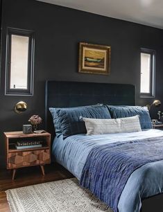 a bedroom with black walls and blue bedding