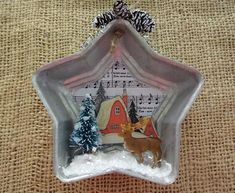 a glass ornament with a deer and christmas tree in the center on a burlap background