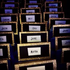 there are many gold and black boxes with name tags on them that say jayyeya