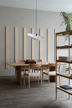 a dining room table and chairs in front of a wall with wooden slats on it