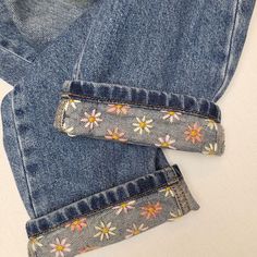 two pairs of jeans with flowers on them