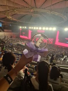 a person holding up a trophy in front of an audience at a convention or show