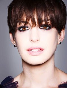 a close up of a person with short hair and eyeshade wearing black dress