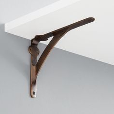 a pair of scissors hanging from the side of a white wall next to a shelf