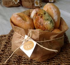 bagels wrapped in brown paper and tied with twine on top of a basket