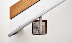 an electrical outlet is attached to the side of a wall with a wooden door handle