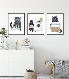 three black cats are hanging on the wall next to a white dresser and a basket