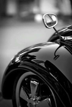 a black and white photo of the front end of a car with chrome rims