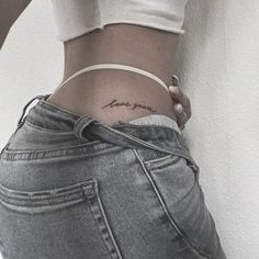 a woman's lower back tattoo with the word love on her left ribcage