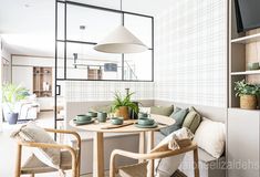 a small table with two chairs and a television mounted to the wall in a living room