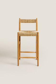 a wooden chair with a woven seat and backrest on a plain background, looking to the side