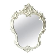 an ornate white mirror is shown against a white background with the reflection of it's frame