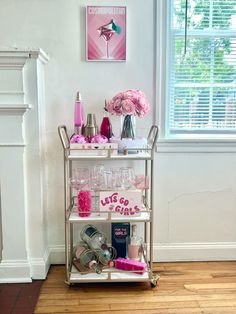 a metal cart filled with lots of bottles and glasses on top of a hard wood floor