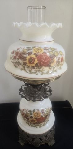 a white vase sitting on top of a black table