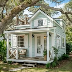 a small white house sitting under a tree