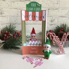 a christmas card with an elf and candy canes on the table next to it