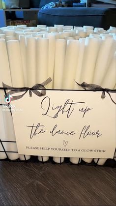 white candles with black ribbon tied around the top are in a basket on a table