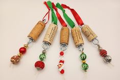 six wine corks with christmas ornaments hanging from them