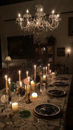 a dining room table is set with candles and plates