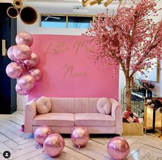 a pink couch and some balloons on the floor