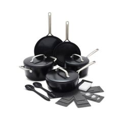 an assortment of black pots and pans with utensils next to them on a white background