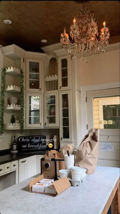 a kitchen with white cabinets and a chandelier