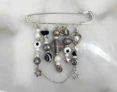 a close up of a brooch pin with beads and charms hanging from it's side