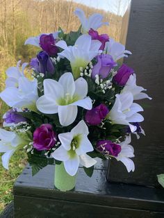 a vase filled with purple and white flowers