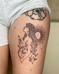 a woman's thigh with a tattoo on it and flowers around her waist,