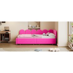 a pink bed sitting in the middle of a living room