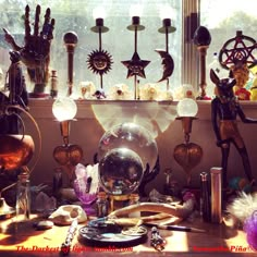 a table topped with lots of different types of glass globes next to a window