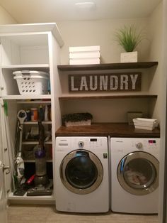 a washer and dryer in a small laundry room with shelves above the washers