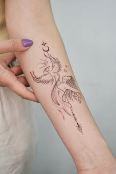 a woman's arm with a bird tattoo on it