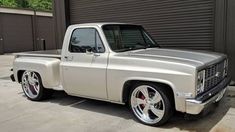 a silver truck parked in front of a garage door