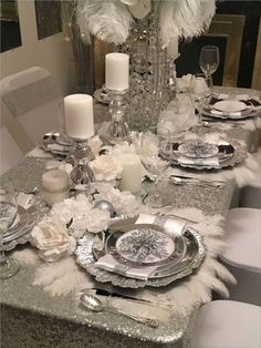 the table is set with silver and white decorations