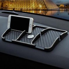 a cell phone is sitting on top of a car dashboard with an air vent in the background