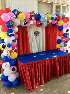 the balloon arch is decorated with balloons and paw prints for an animal themed birthday party