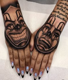 two hands that have tattoos on them with clown faces painted on the palms and fingers