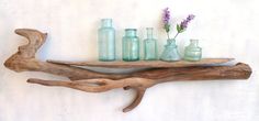 a shelf made out of driftwood with vases on it