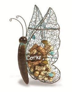 a wire sculpture with a butterfly on it's back and some rocks in the front