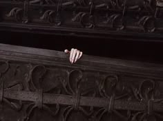 a person's hand resting on the edge of a wooden bench