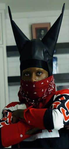 a person wearing a cat mask and bandana with horns on their head is posing for the camera