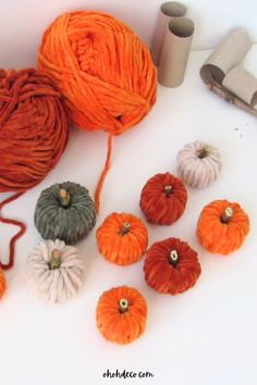 yarn and pumpkins are sitting on the table next to some crochet hooks