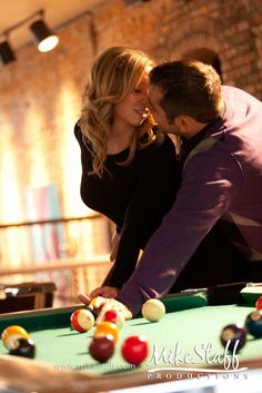 a man and woman leaning over a pool table