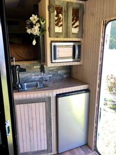 a kitchen area with sink, dishwasher and microwave in an airstreame