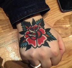 a person's hand with a tattoo on it and a rose on the wrist