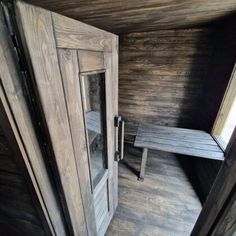 the inside of a small cabin with wooden floors and walls, looking down at an open door